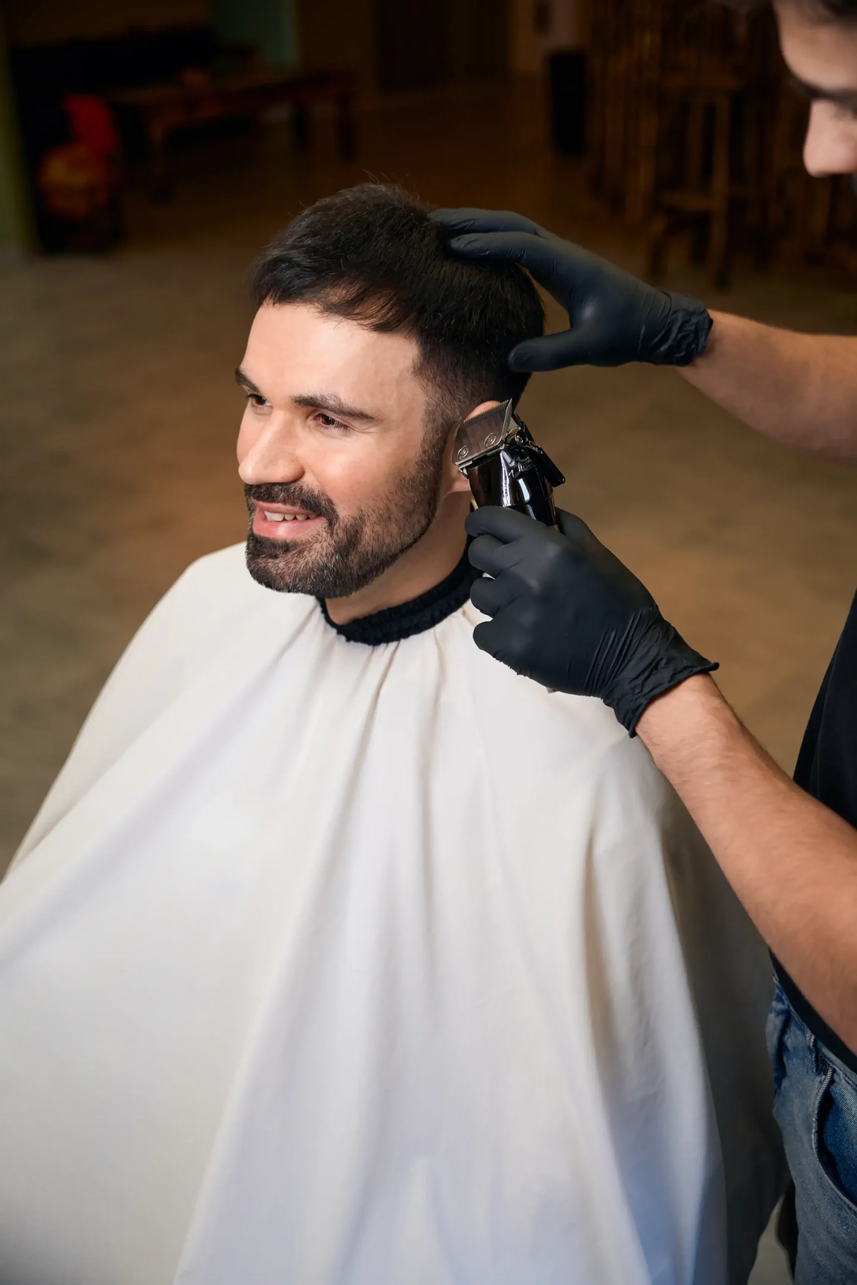 Customer smiling while getting a haircut at a friendly barbershop.